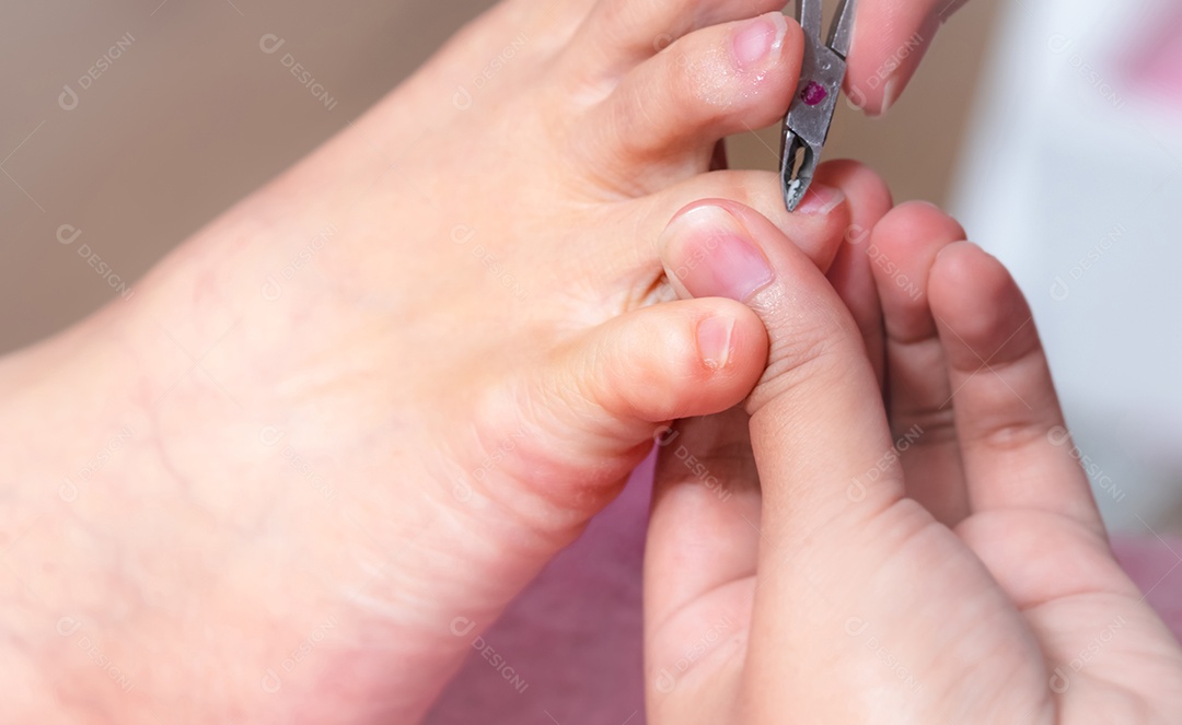 Mulher recebendo serviço de pedicure de unhas por pedicuro profissional