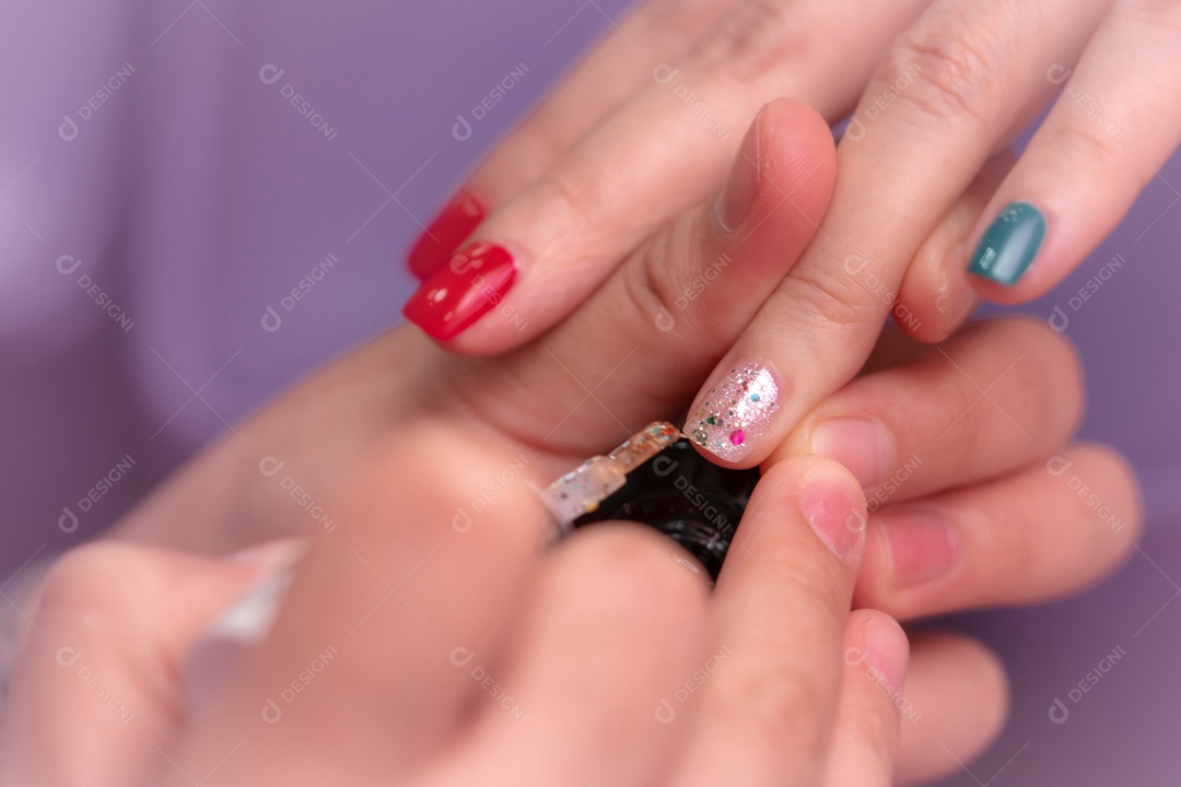 Mulheres recebendo serviço de manicure de unhas por manicure profissional