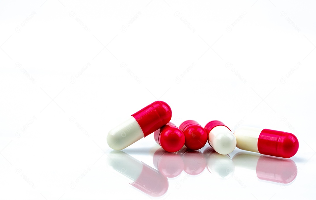 Pílula de cápsula de antibiótico vermelho-branco isolada no fundo branco.