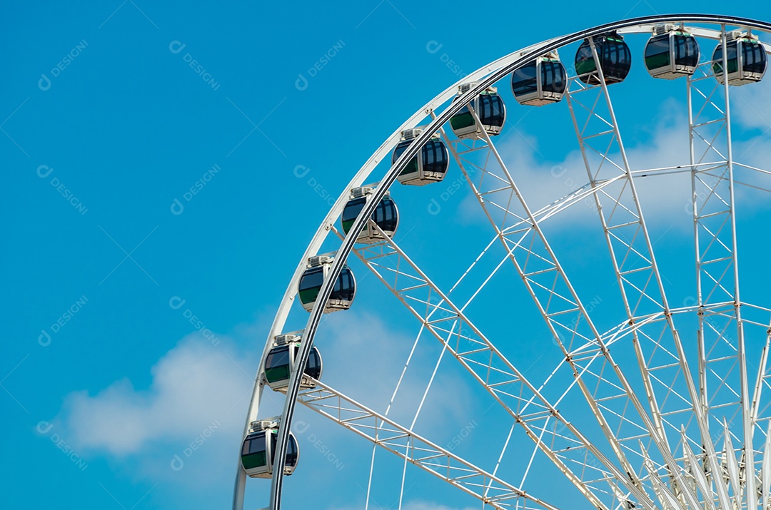 Closeup roda gigante moderna contra o céu azul e nuvens brancas.