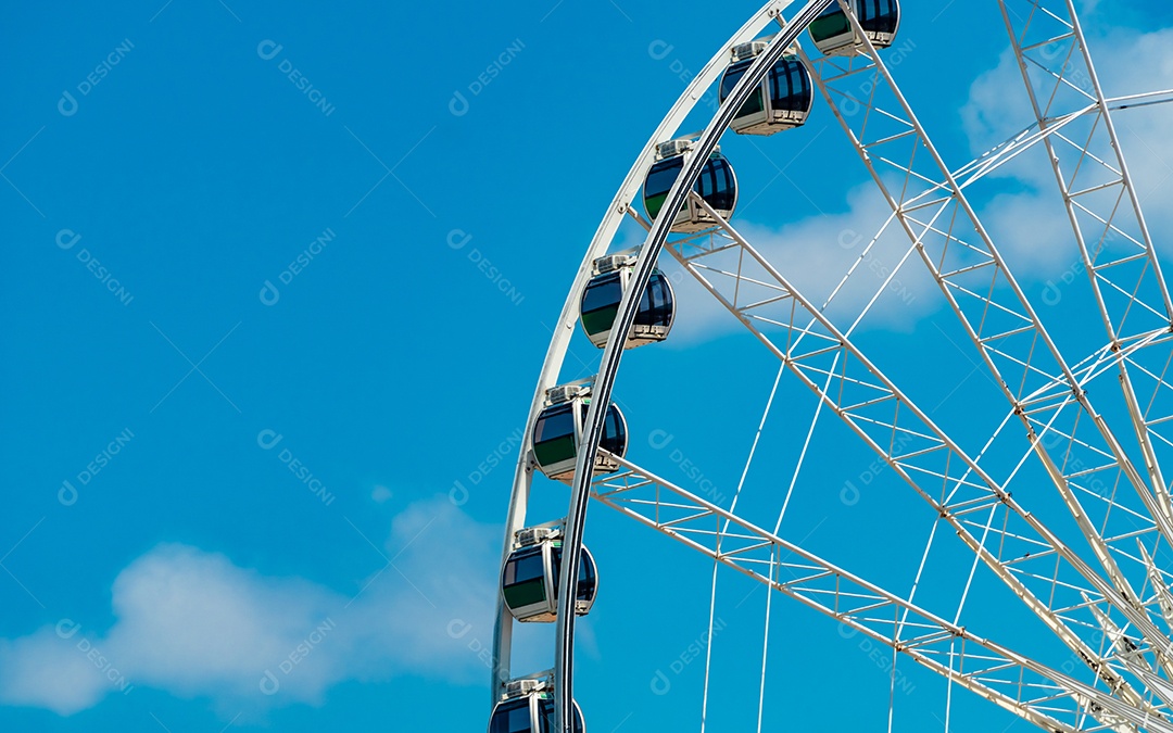 Closeup roda gigante moderna contra o céu azul e nuvens brancas.