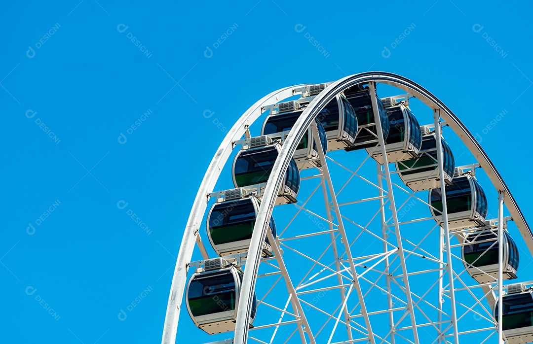 Closeup roda gigante moderna contra o céu azul e nuvens brancas.