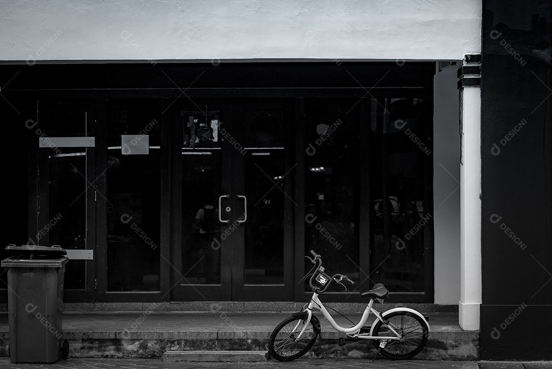 Bicicleta para alugar estacionada no chão de concreto em frente ao prédio de escritórios