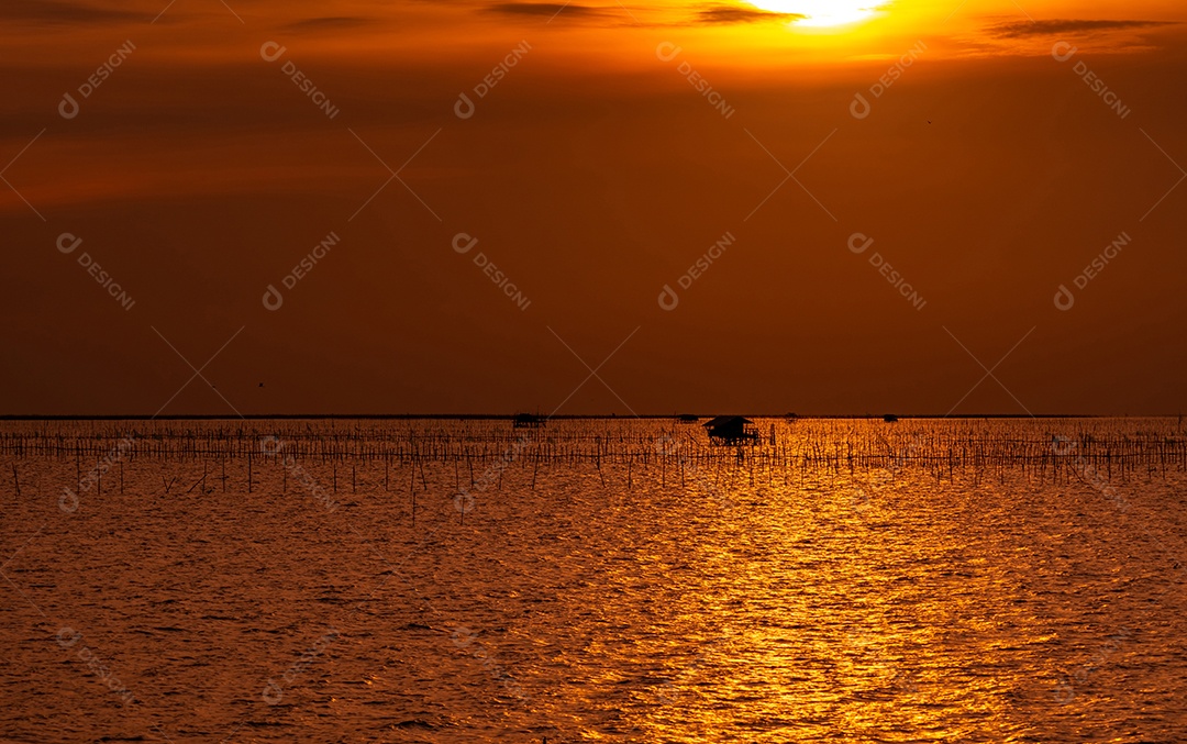 Belo pôr do sol sobre o mar. Céu escuro e dourado do pôr do sol