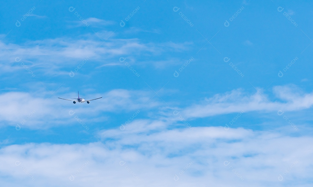 Companhia aérea comercial voando no céu azul e nuvens fofas brancas.