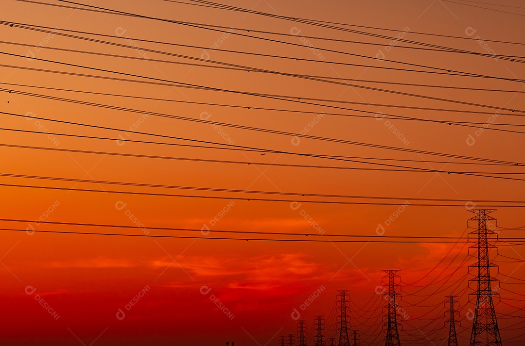 Pilão elétrico de alta tensão e fio elétrico com céu pôr do sol.