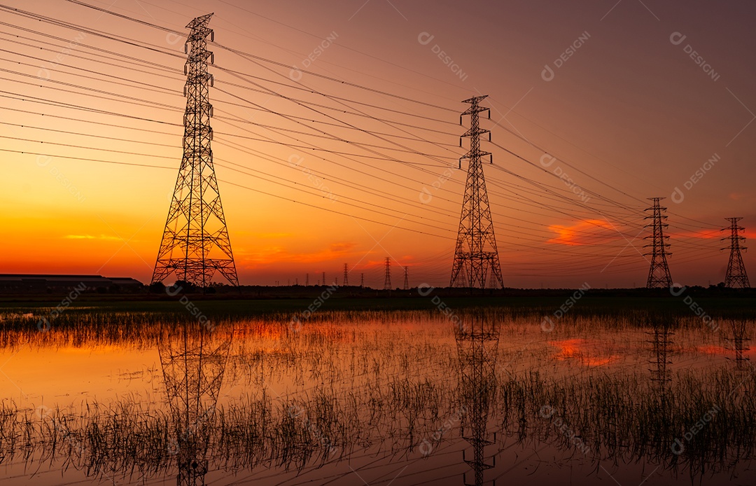 Pilão elétrico de alta tensão e fio elétrico com céu pôr do sol.
