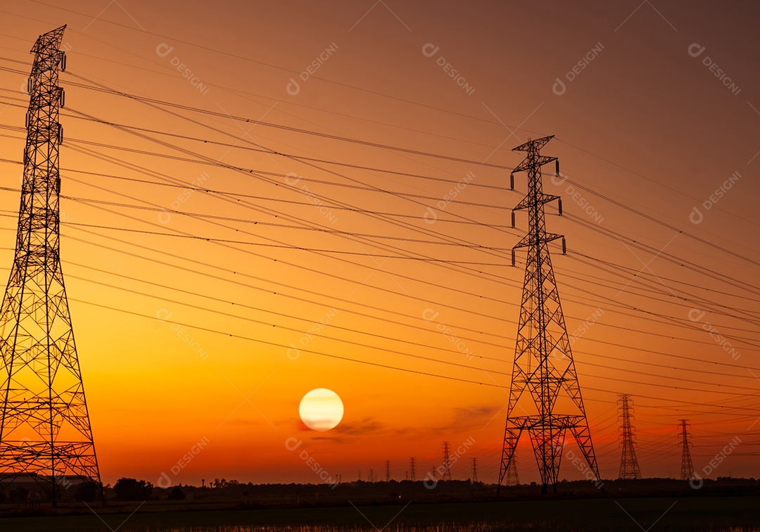 Pilão elétrico de alta tensão e fio elétrico com céu pôr do sol.