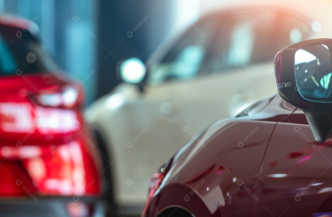 Espelho lateral fechado do carro vermelho em SUV desfocado estacionado