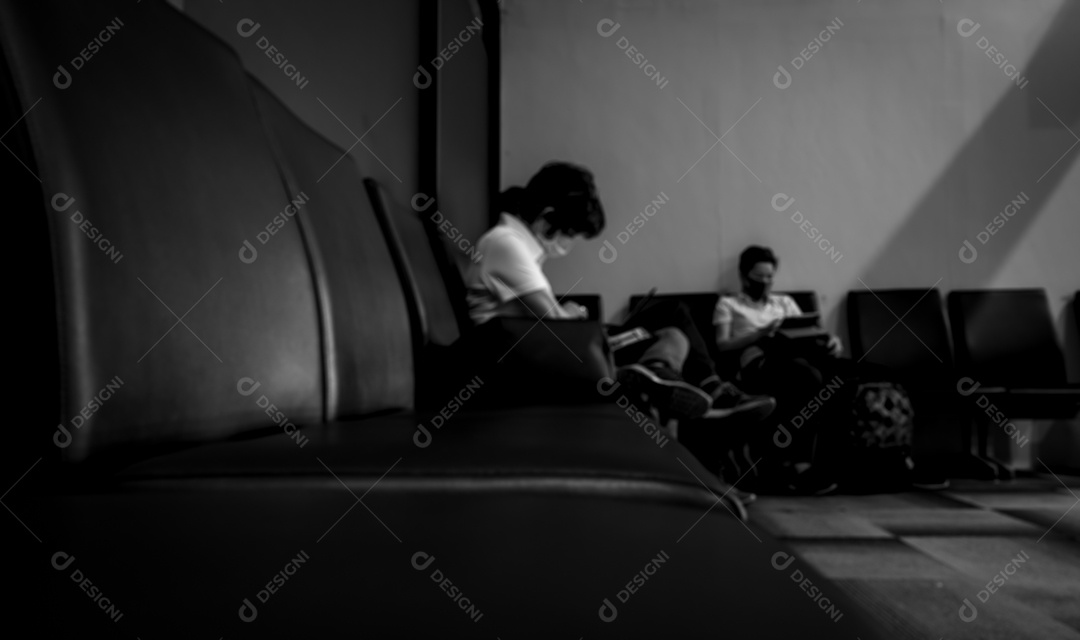 Mulher borrada usa máscara cirúrgica e senta-se no assento usando laptop