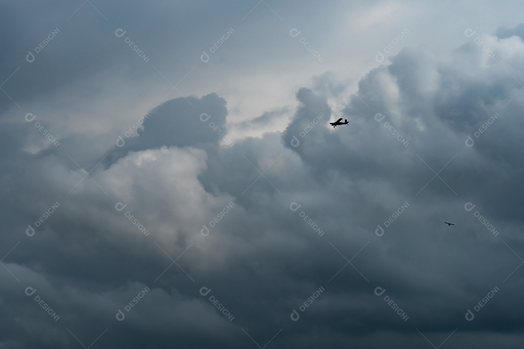 Pequeno avião em céu nublado para fazer chuva. Nuvens fofas brancas