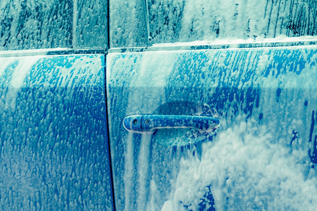 Lavagem de carro azul com espuma de sabão branco. Negócio de auto cuidado.