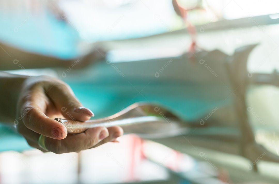 Mulher que trabalha na máquina de tecelagem para tecer tecido artesanal.