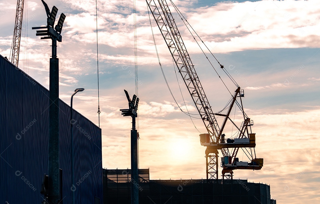 Guindaste de construção silhueta contra o céu pôr do sol. Carretel de uso do guindaste