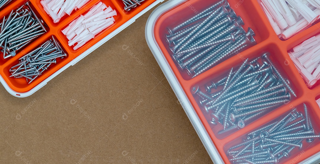 Parafusos de aço prateado e bucha em caixa de plástico laranja.