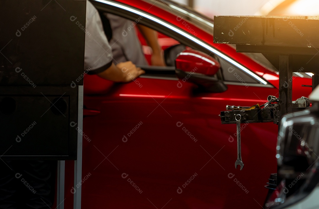 A chave pendura no porta-ferramentas na oficina no carro SUV vermelho turvo