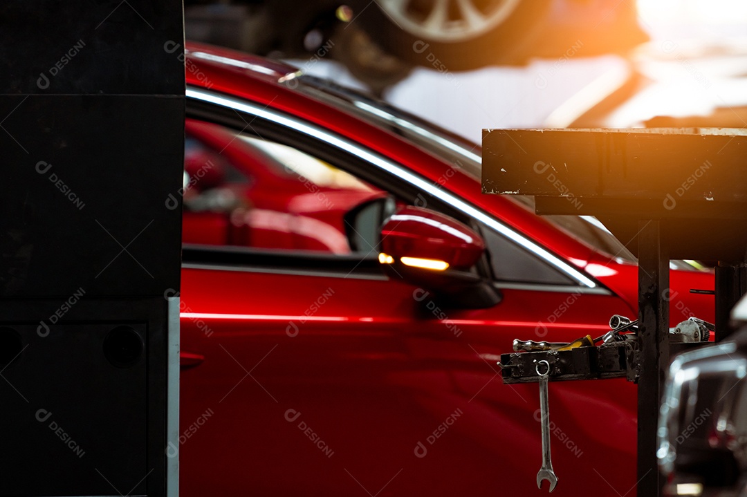 A chave pendura no porta-ferramentas na oficina no carro SUV vermelho turvo