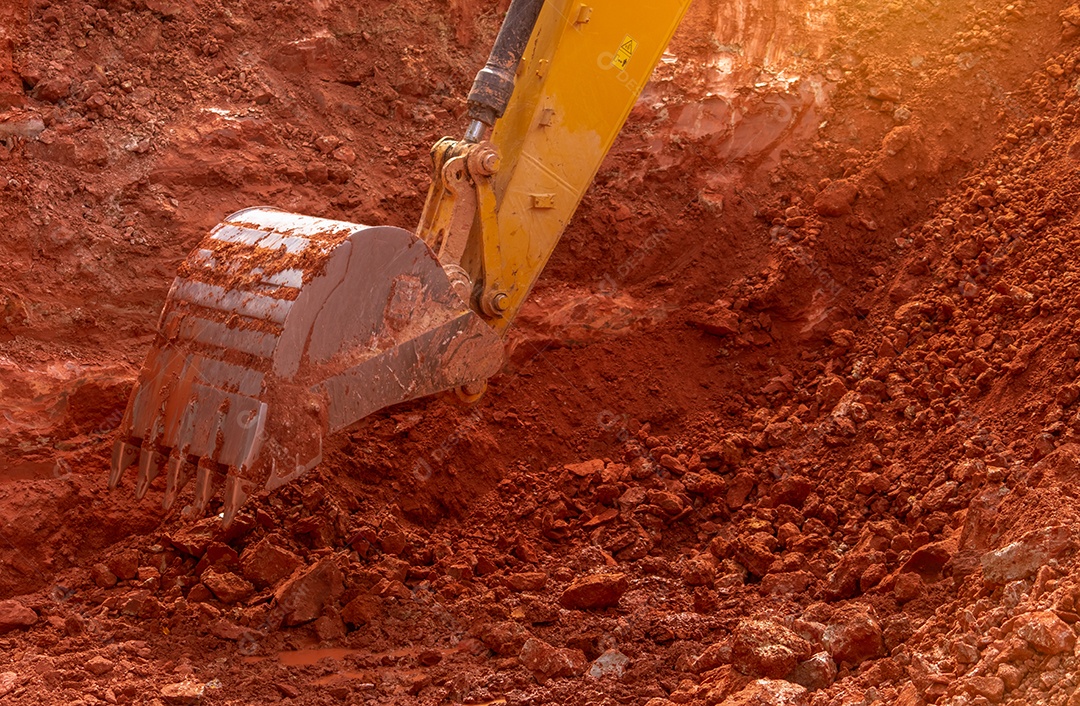 Retroescavadeira trabalhando cavando o solo no canteiro de obras.