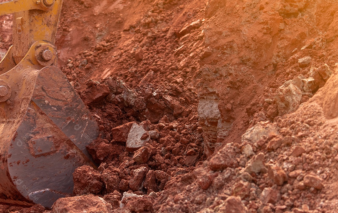 Retroescavadeira trabalhando cavando o solo no canteiro de obras.