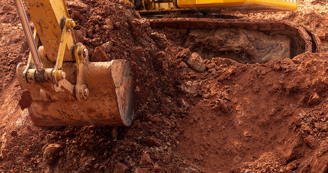 Retroescavadeira trabalhando cavando o solo no canteiro de obras.