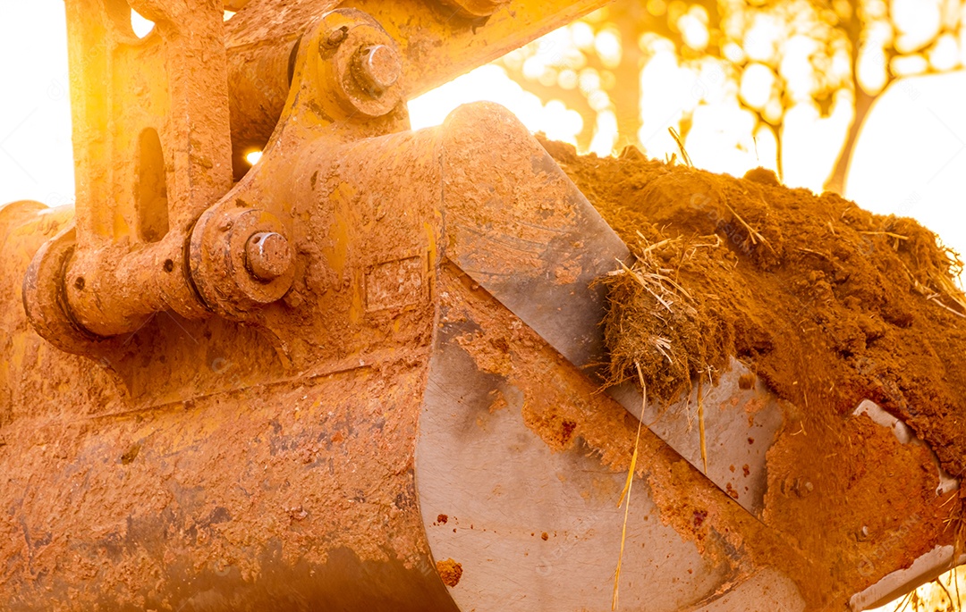 Retroescavadeira trabalhando cavando o solo no canteiro de obras.