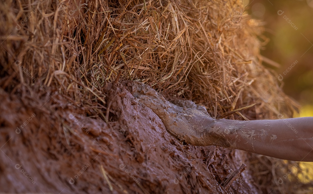 A mão do homem aproximado fazendo forno de carvão usando argila misturada