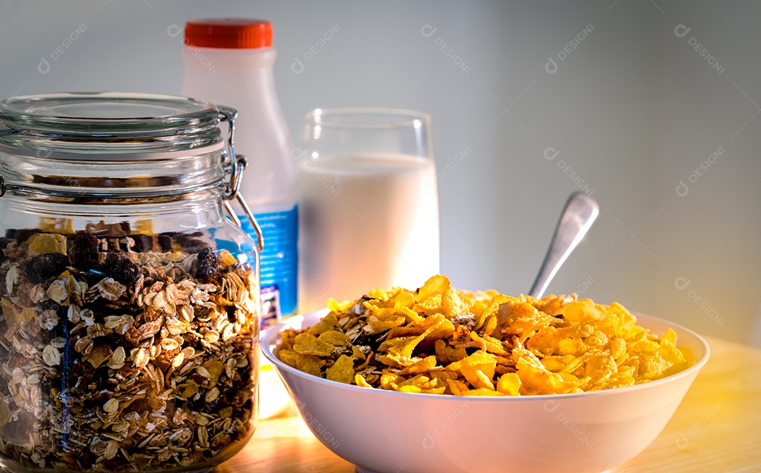 Tigela de cereal com colher colocada na mesa de madeira perto de granola