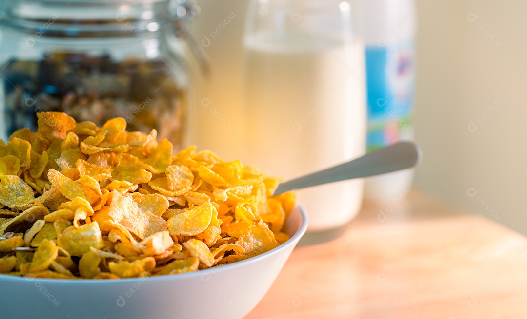 Tigela de cereal com colher colocada na mesa de madeira perto de granola