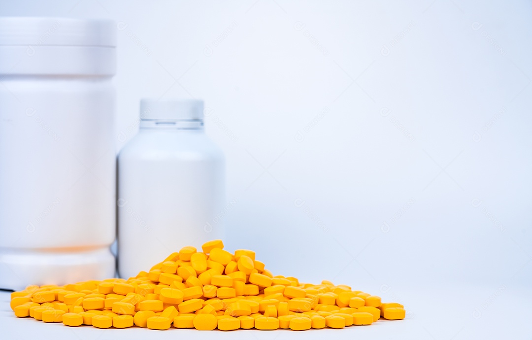 Pilha de comprimidos de comprimidos amarelos perto de frasco de comprimidos