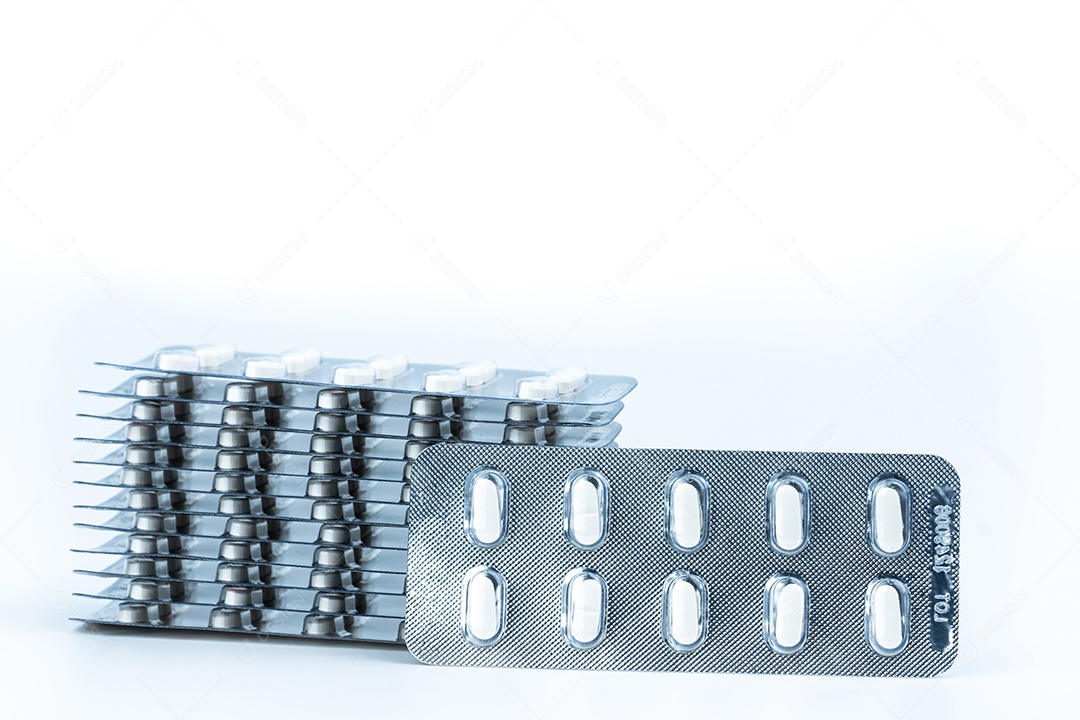 Pilhas de comprimidos comprimidos brancos isolados no fundo branco.