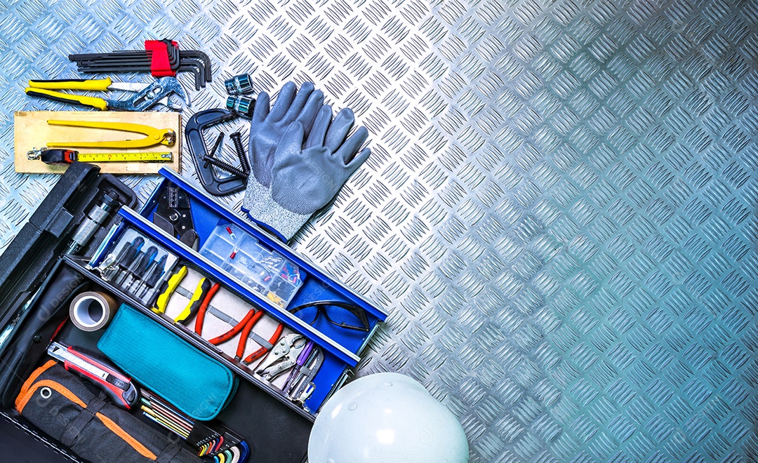 Vista superior da caixa de ferramentas e capacete no fundo da placa quadriculada