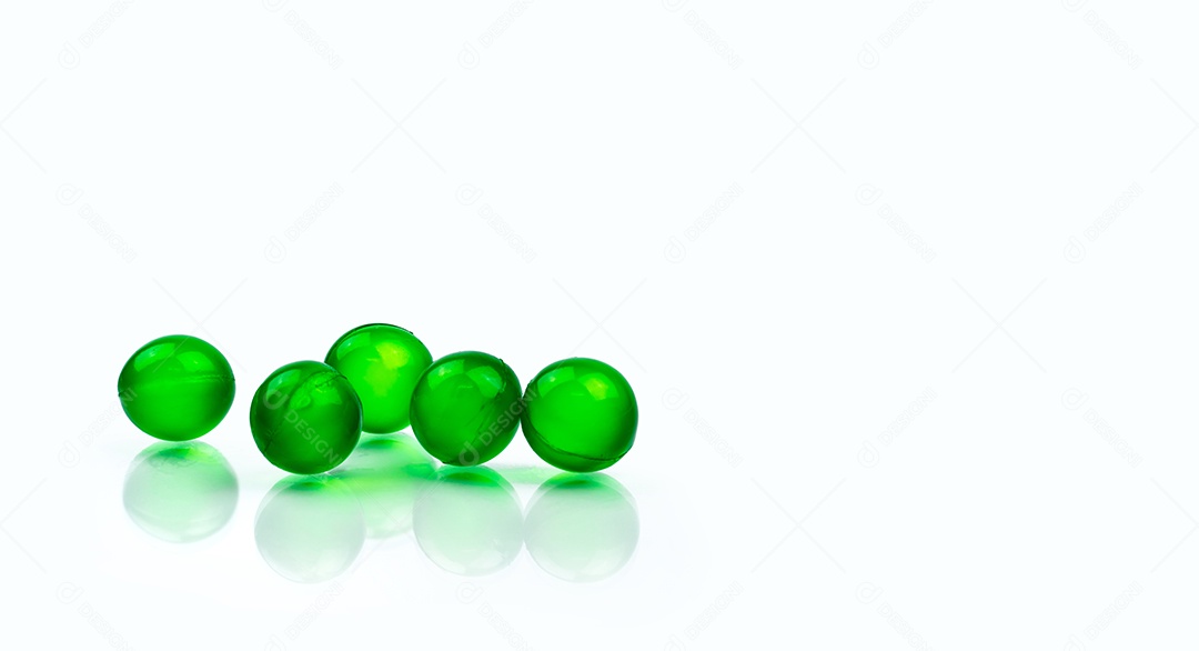 Comprimidos redondos verdes da cápsula macia isolados no fundo branco