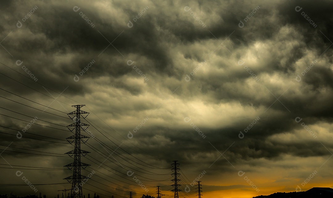 Céu escuro dramático e nuvens e poste de alta tensão com eletricidade