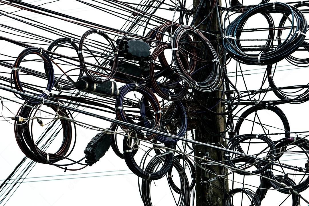 Fios elétricos emaranhados no poste elétrico urbano.