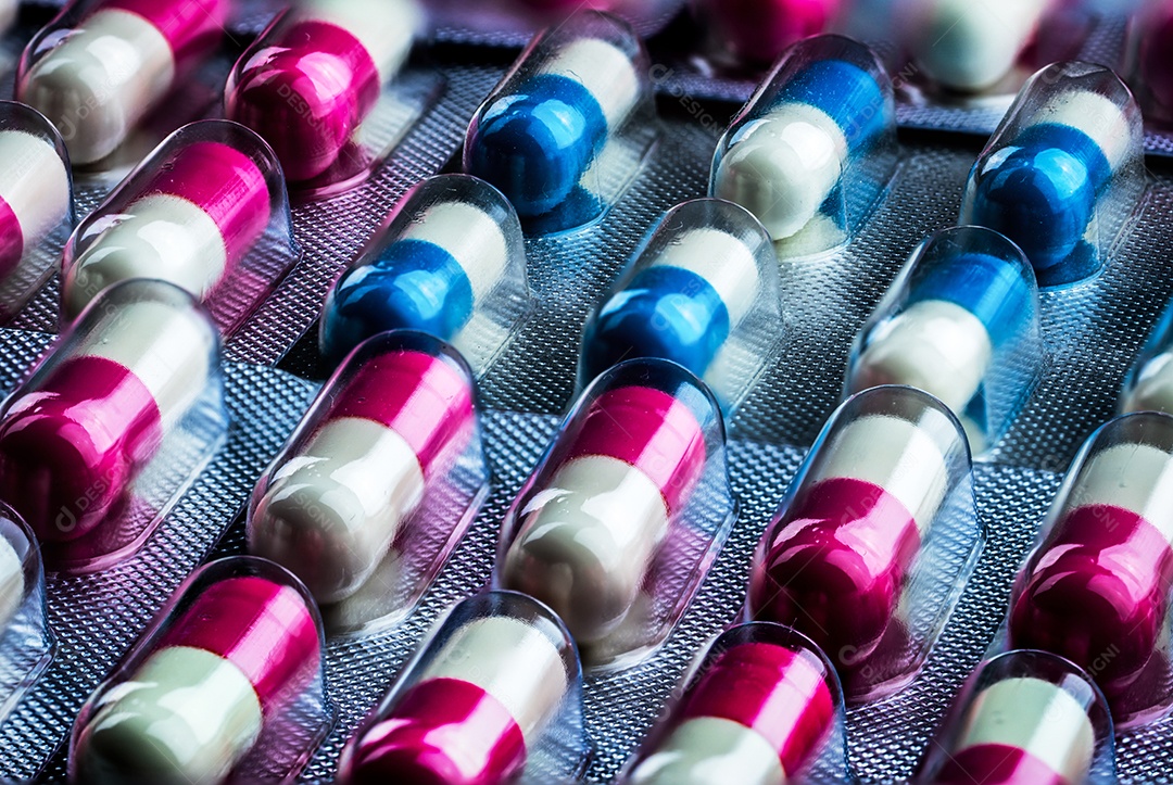 Closeup pílulas de cápsula de antibióticos rosa-branco e azul-branco