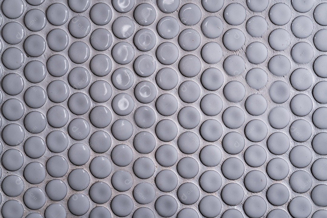 Parede de cerâmica branca com muitos pequenos padrões redondos únicos.