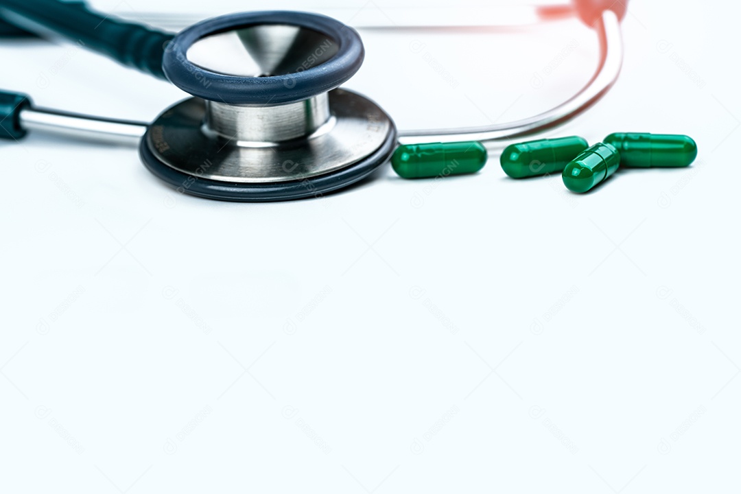 Estetoscópio com quatro comprimidos verdes da cápsula do antibiótico