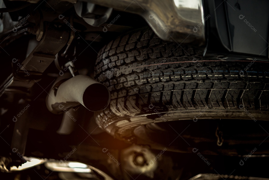 Pneu sobressalente sob o carro perto do tubo de escape.