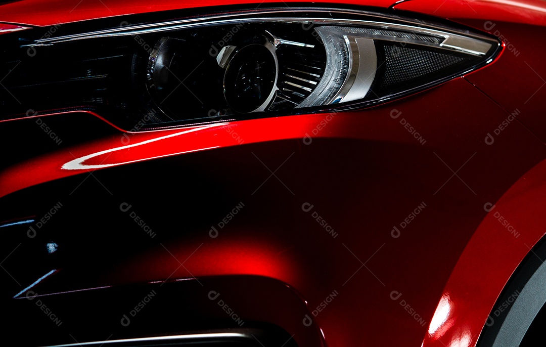 Farol do close up do carro compacto SUV luxuoso vermelho brilhante.