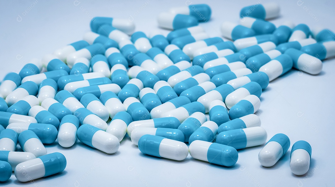 Comprimidos cápsula azul e branco sobre fundo branco.
