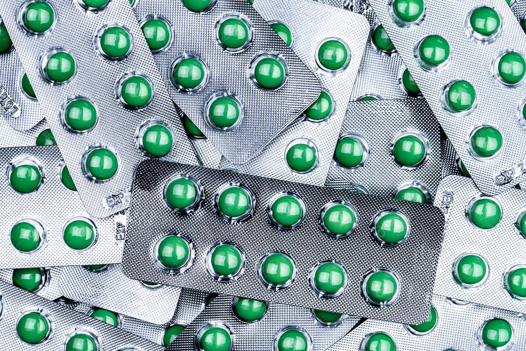 Pilha aproximada de comprimidos redondos verdes revestidos de açúcar em blister