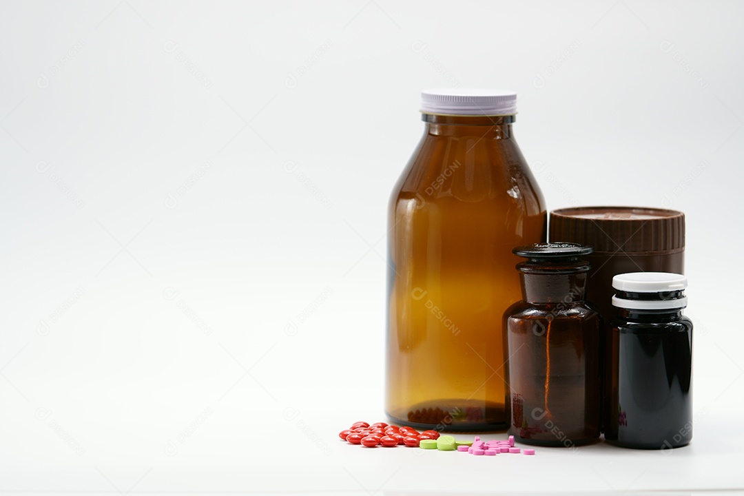 Comprimidos rosa, verdes e vermelhos sobre fundo branco com droga âmbar