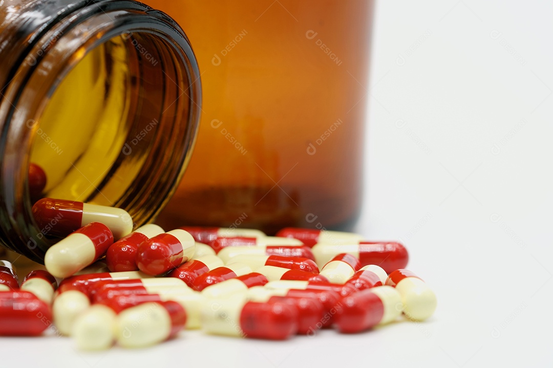 Comprimidos de cápsulas de antibióticos e frasco de vidro âmbar sobre fundo branco