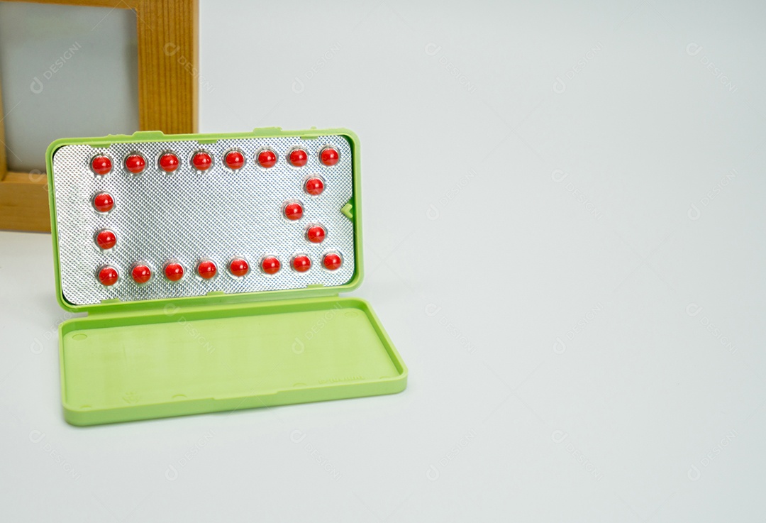 Pílulas anticoncepcionais em blister na mesa branca.