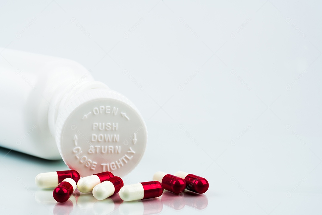 Comprimidos das cápsulas no fundo branco e na garrafa plástica com espaço em branco