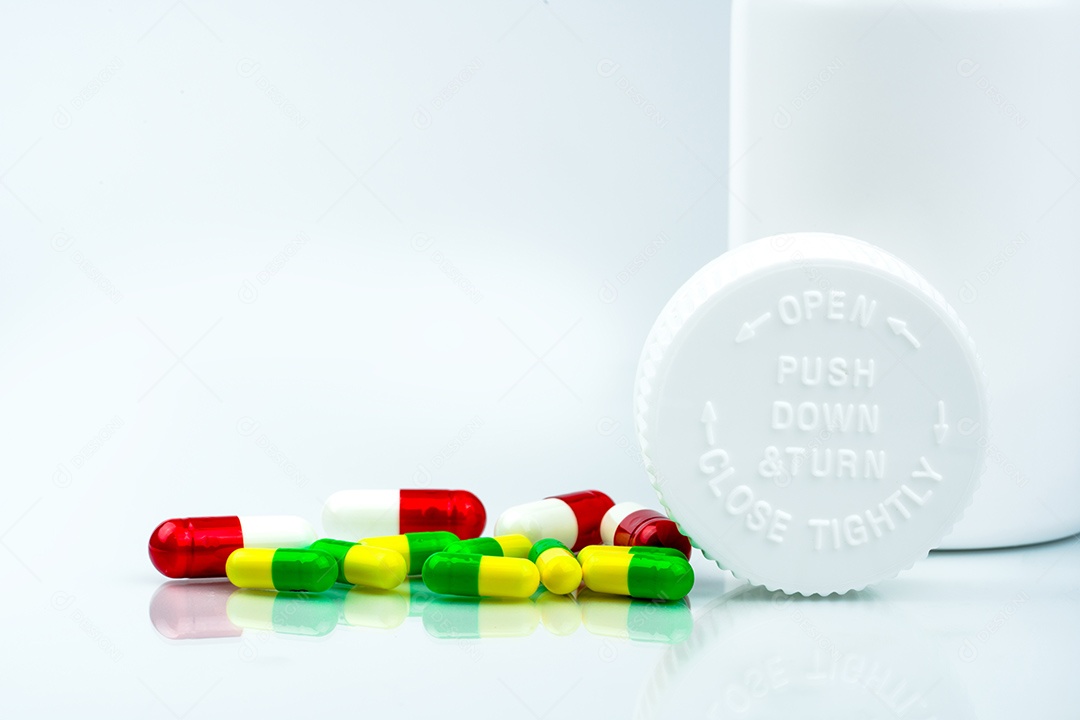 Pílulas coloridas em fundo branco e garrafa de plástico com espaço em branco