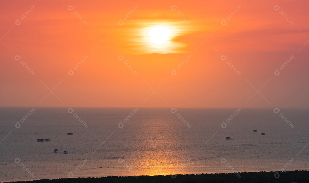 Belo pôr do sol e reflexões sobre o mar com céu laranja