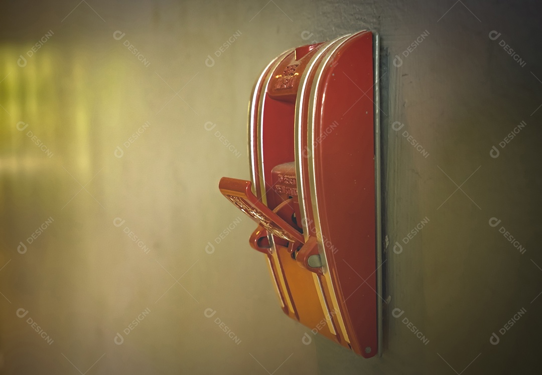 Alarme de incêndio laranja na parede de concreto. Sistema de alerta e segurança.