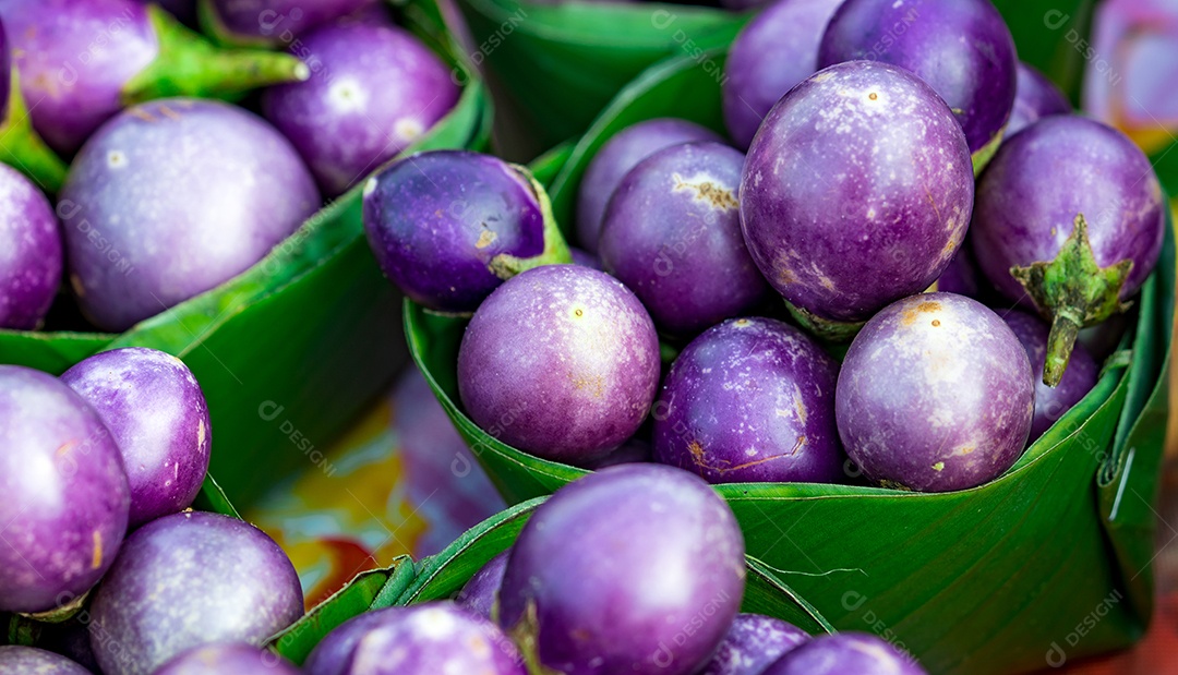 Beringelas roxas em folhas de bananeira empacotadas no mercado da Tailândia
