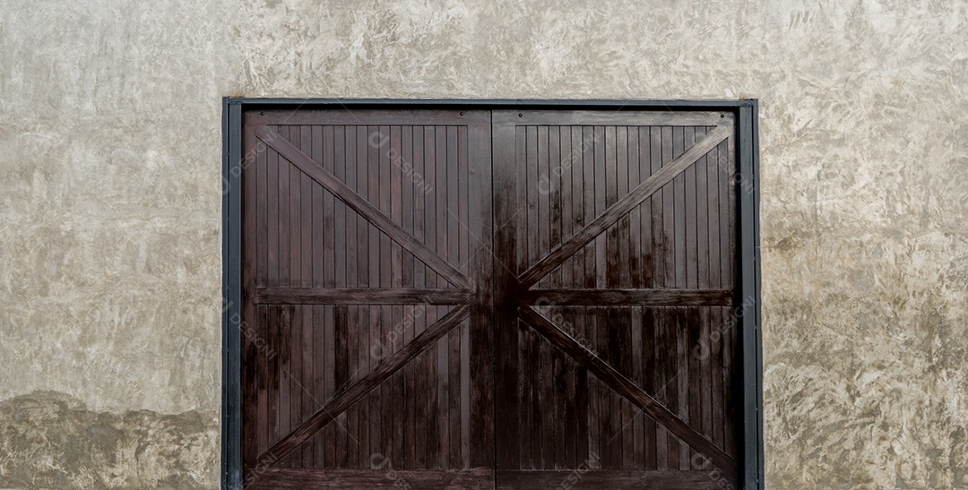 Paredes de concreto com grandes portas de madeira.